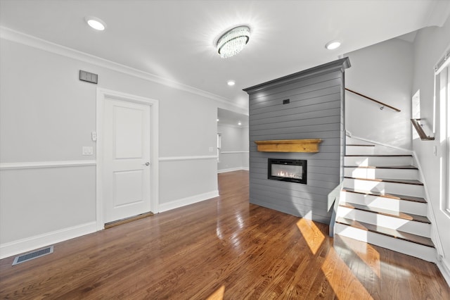 unfurnished living room featuring dark hardwood / wood-style floors and ornamental molding