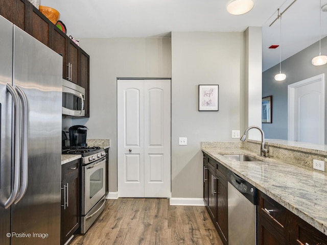 757 N Orleans St Unit 1612, Chicago, IL 60654 - kitchen featuring stainless steel appliances, a sink, dark wood-style flooring, dark brown cabinetry, and light stone counters