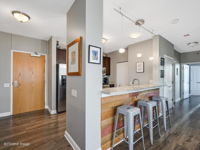 757 N Orleans St Unit 1612, Chicago, IL 60654 - kitchen featuring appliances with stainless steel finishes, dark wood finished floors, a breakfast bar area, and baseboards