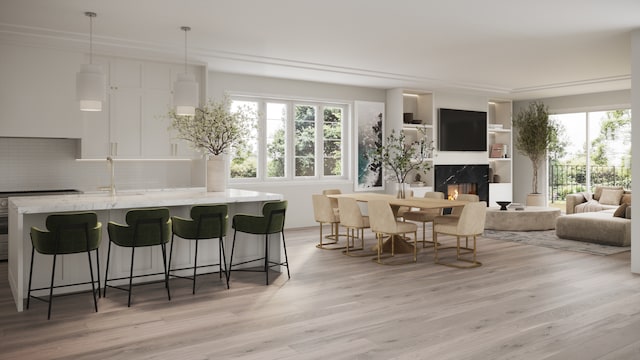 dining room featuring sink, light hardwood / wood-style flooring, and a fireplace