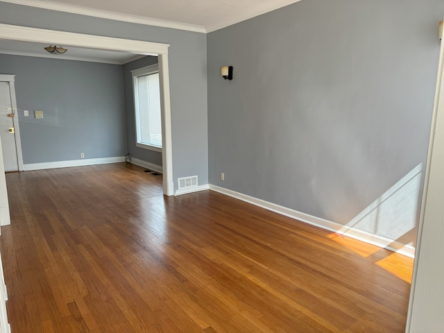 empty room featuring hardwood / wood-style flooring and crown molding