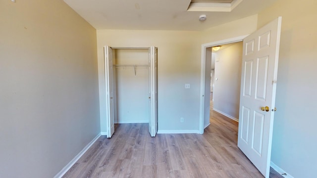 unfurnished bedroom with light hardwood / wood-style flooring and a closet