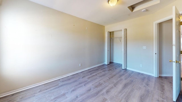 unfurnished bedroom featuring light hardwood / wood-style flooring and a closet