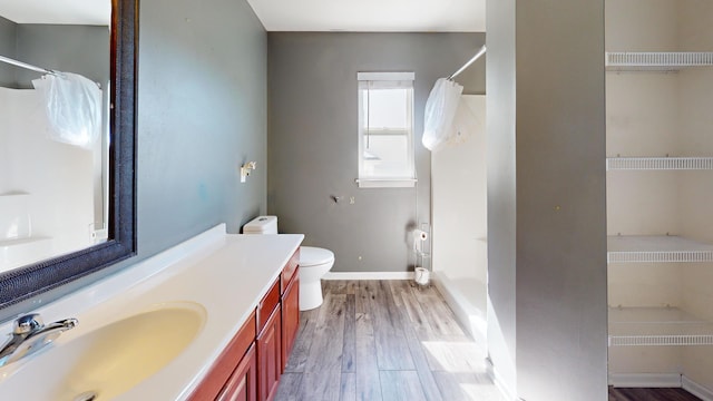 bathroom featuring hardwood / wood-style floors, a shower with curtain, vanity, and toilet