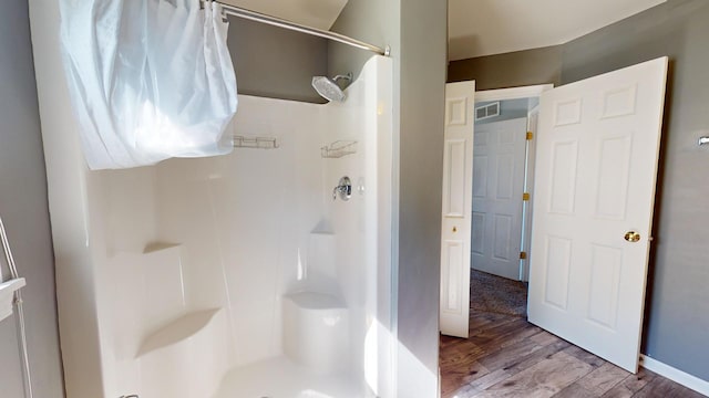 bathroom featuring walk in shower and hardwood / wood-style floors