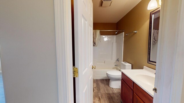 full bathroom featuring wood-type flooring, vanity, bathtub / shower combination, and toilet