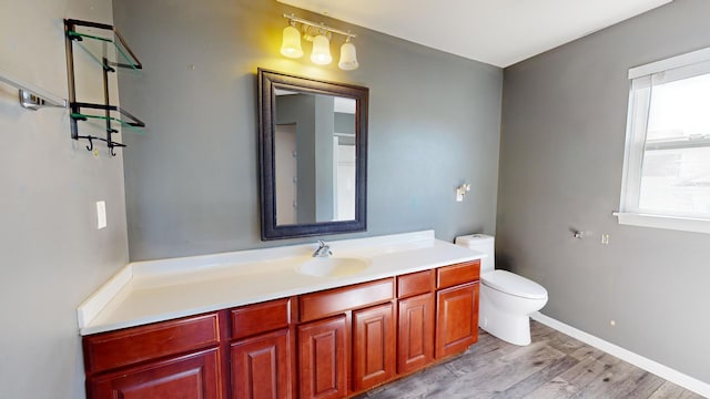 bathroom with vanity, toilet, and hardwood / wood-style flooring