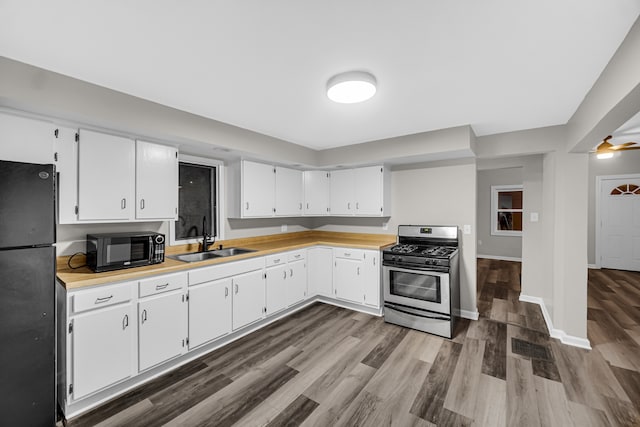 kitchen with ceiling fan, sink, dark wood-type flooring, white cabinetry, and black appliances