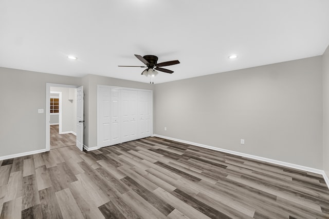 unfurnished bedroom featuring a closet, ceiling fan, and wood-type flooring