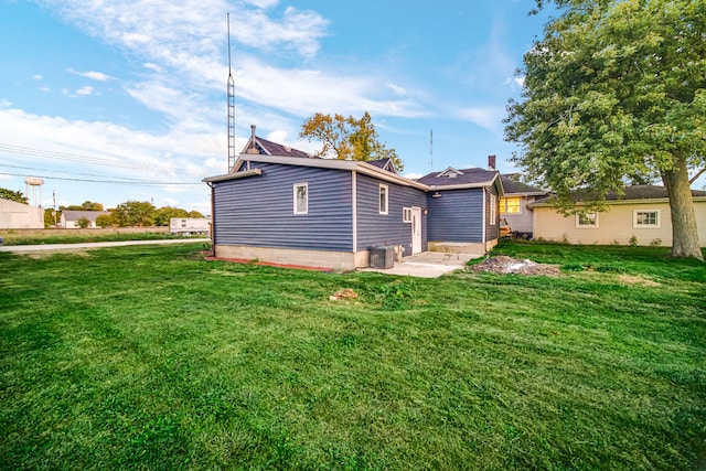 back of property with a lawn and a patio area