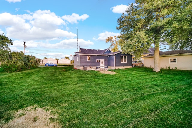 rear view of property featuring a yard