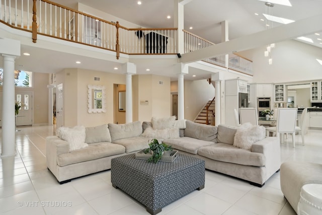 tiled living room with ornate columns and high vaulted ceiling