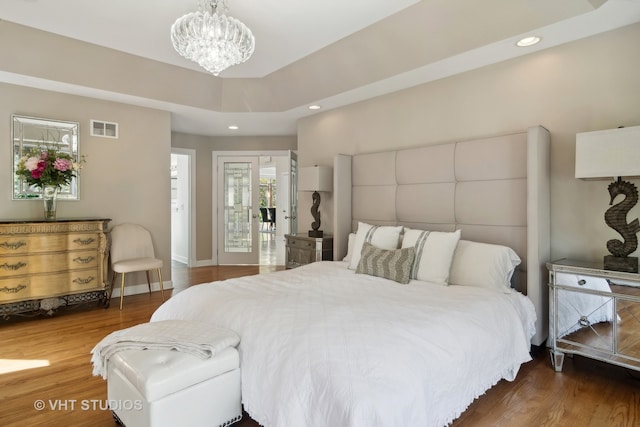 bedroom featuring access to exterior, a notable chandelier, and dark wood-type flooring