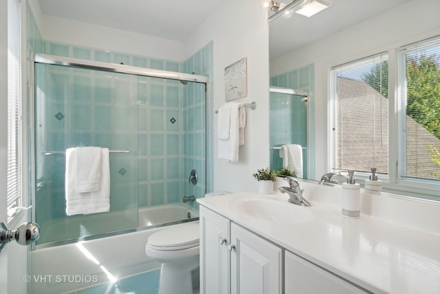 full bathroom with vanity, toilet, and combined bath / shower with glass door