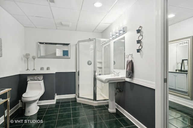 bathroom featuring a drop ceiling, toilet, tile patterned floors, and an enclosed shower