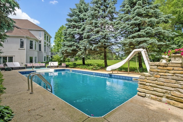 view of swimming pool with outdoor lounge area, a water slide, and a patio area