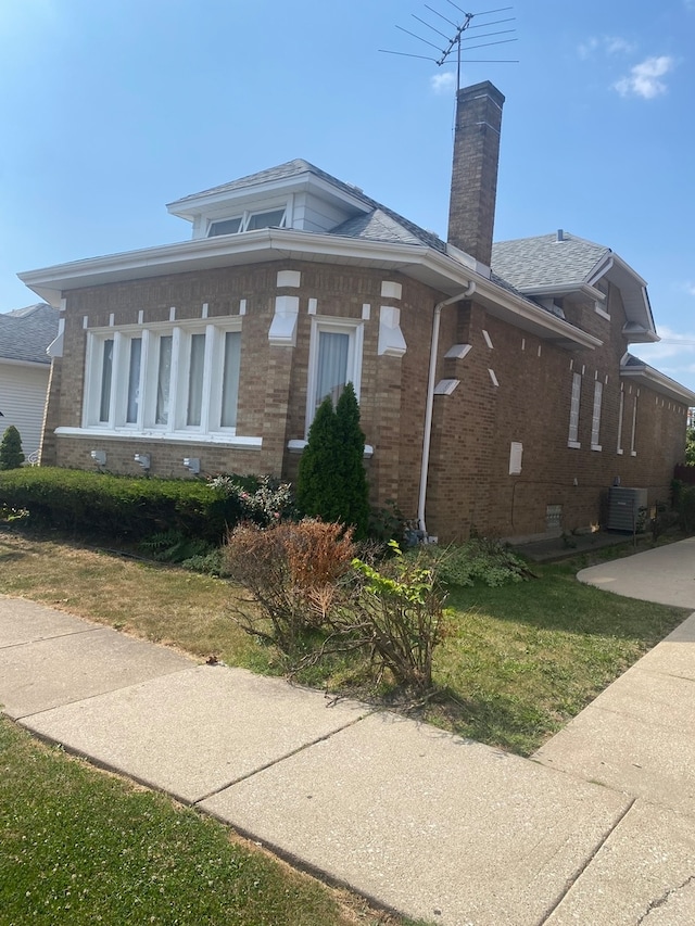 view of property exterior featuring a lawn and central AC unit