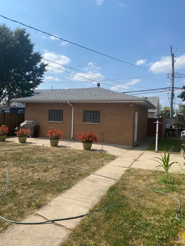 rear view of house featuring a lawn and a patio