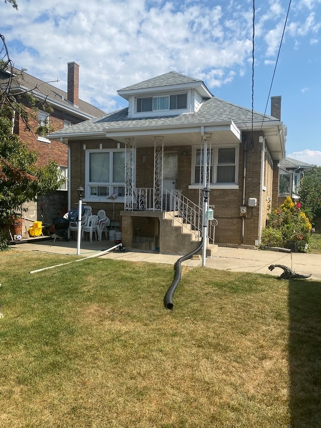 rear view of property featuring a lawn