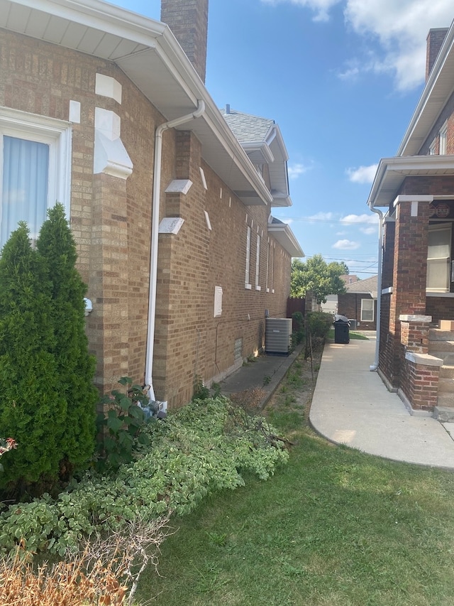 view of property exterior with a patio, a yard, and central AC