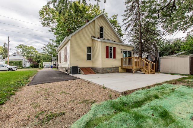 back of property featuring central AC and a yard