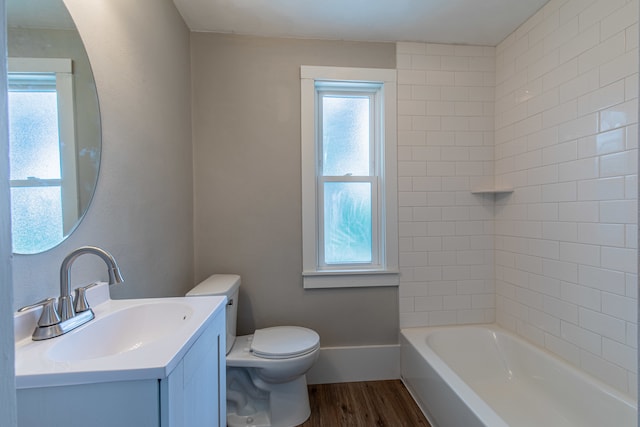 full bathroom featuring tiled shower / bath, hardwood / wood-style flooring, vanity, and toilet