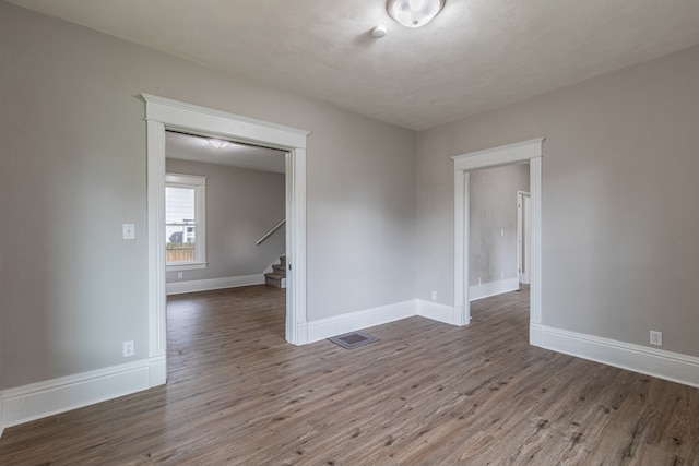 empty room with dark hardwood / wood-style flooring