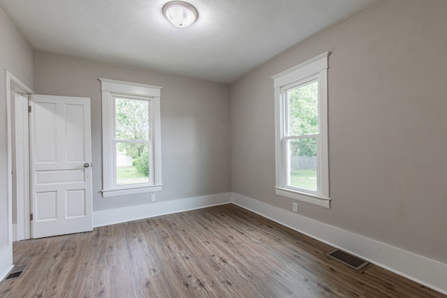 empty room with plenty of natural light and light hardwood / wood-style floors