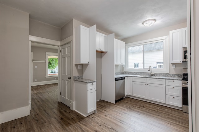 kitchen featuring stainless steel appliances, white cabinets, hardwood / wood-style flooring, and sink