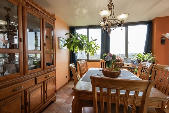 dining room with dark tile patterned floors and a notable chandelier