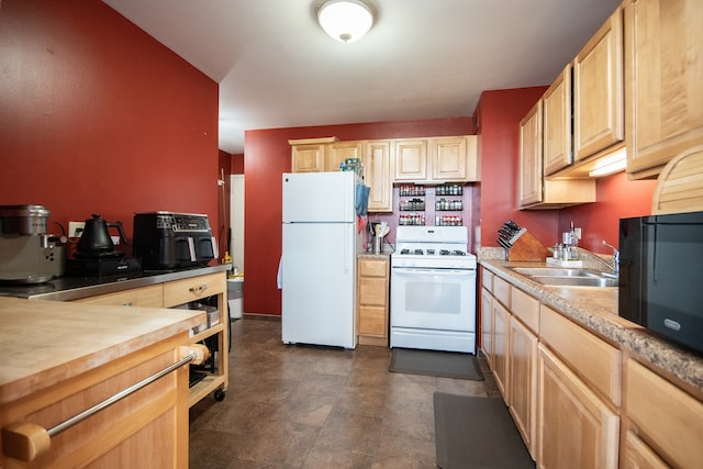 kitchen featuring light brown cabinetry, sink, and white appliances