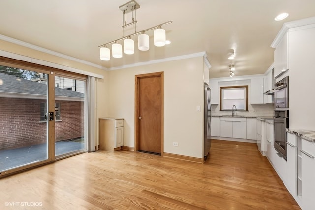 kitchen with decorative light fixtures, light wood-type flooring, stainless steel fridge, and white cabinetry