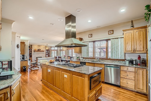 kitchen featuring a center island, sink, island exhaust hood, light hardwood / wood-style flooring, and stainless steel appliances