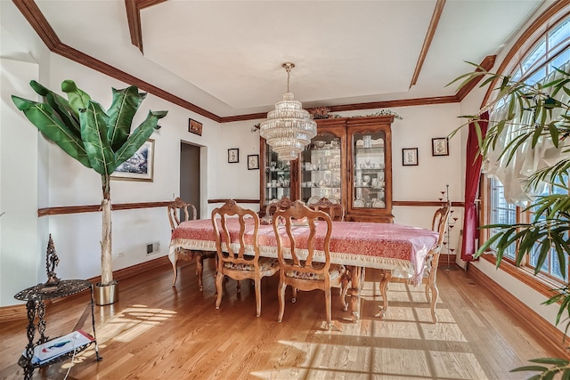 dining room featuring ornamental molding, a notable chandelier, and light hardwood / wood-style floors