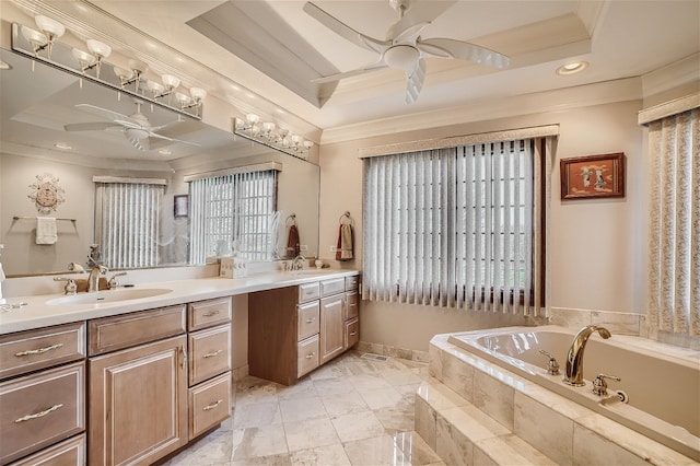 bathroom featuring ceiling fan, vanity, a raised ceiling, ornamental molding, and a relaxing tiled tub