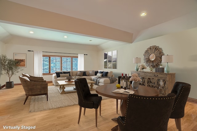 dining area with light wood-type flooring and lofted ceiling