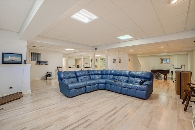 living room with a drop ceiling and light hardwood / wood-style flooring