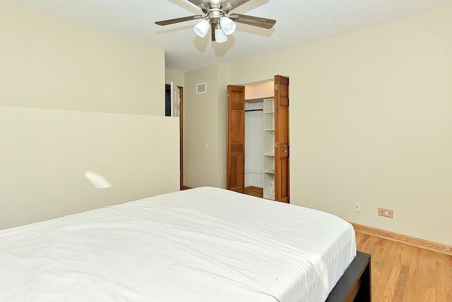 bedroom with ceiling fan, light hardwood / wood-style flooring, and a closet