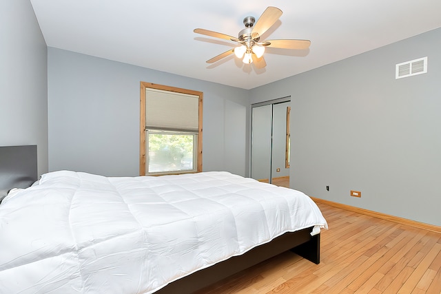 bedroom with ceiling fan, a closet, and light hardwood / wood-style floors