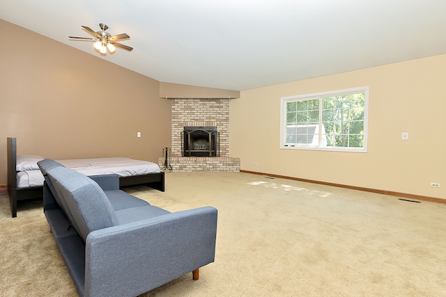 carpeted bedroom featuring vaulted ceiling, ceiling fan, and a fireplace