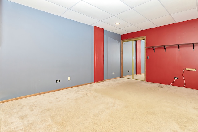 spare room with a drop ceiling and carpet flooring