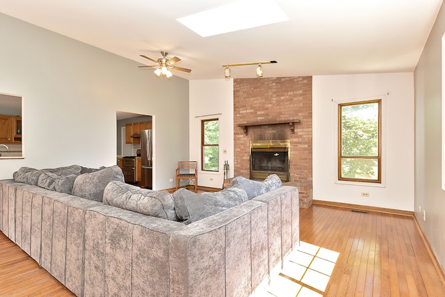 living room featuring a healthy amount of sunlight, ceiling fan, and light hardwood / wood-style flooring