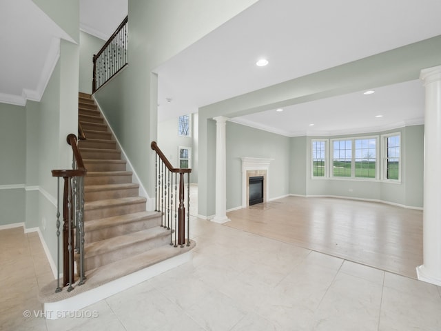 unfurnished living room featuring ornate columns, light hardwood / wood-style floors, and ornamental molding