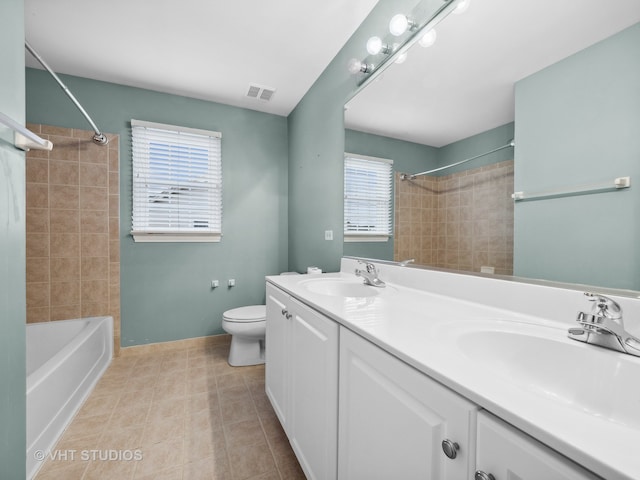 full bathroom featuring vanity, tiled shower / bath combo, and toilet