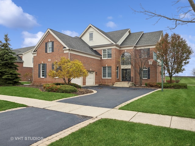 view of property with a garage and a front lawn