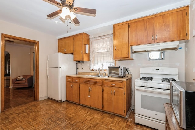 kitchen featuring ceiling fan, dark parquet flooring, sink, and white appliances