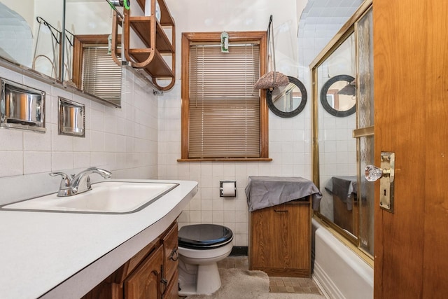 full bathroom with toilet, enclosed tub / shower combo, tile walls, tile patterned floors, and vanity