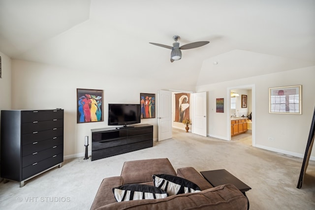 carpeted living room with ceiling fan and vaulted ceiling