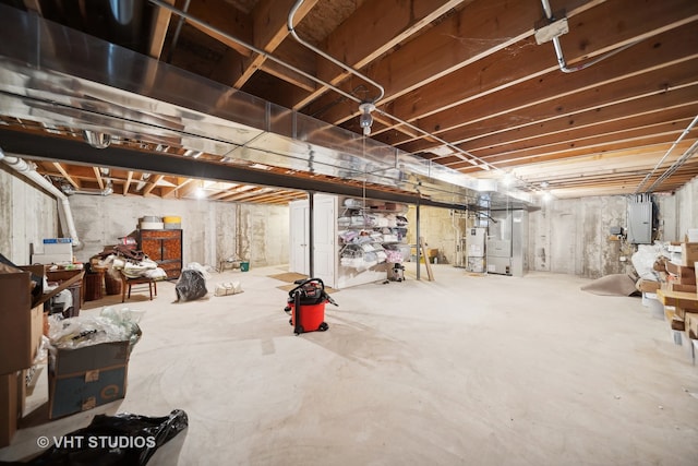 basement featuring electric panel and water heater