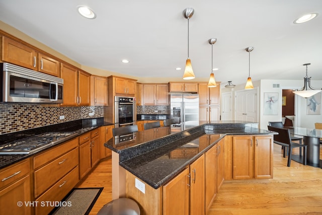 kitchen featuring pendant lighting, light hardwood / wood-style floors, and stainless steel appliances